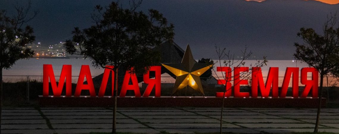 Large red letters spell "malaya zemlya" with a star.