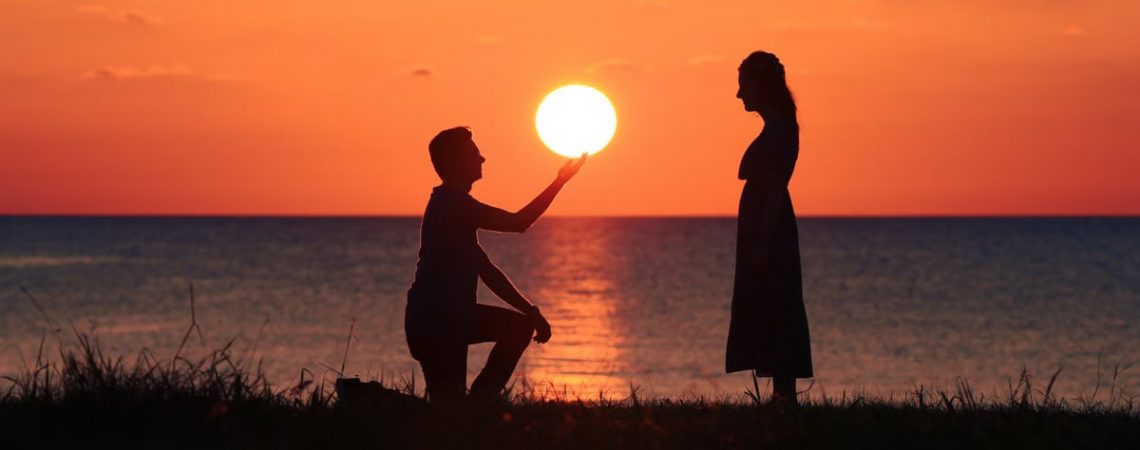 Silhouetted couple at seaside during sunset, expressing love and connection in Turkey's scenic landscape.